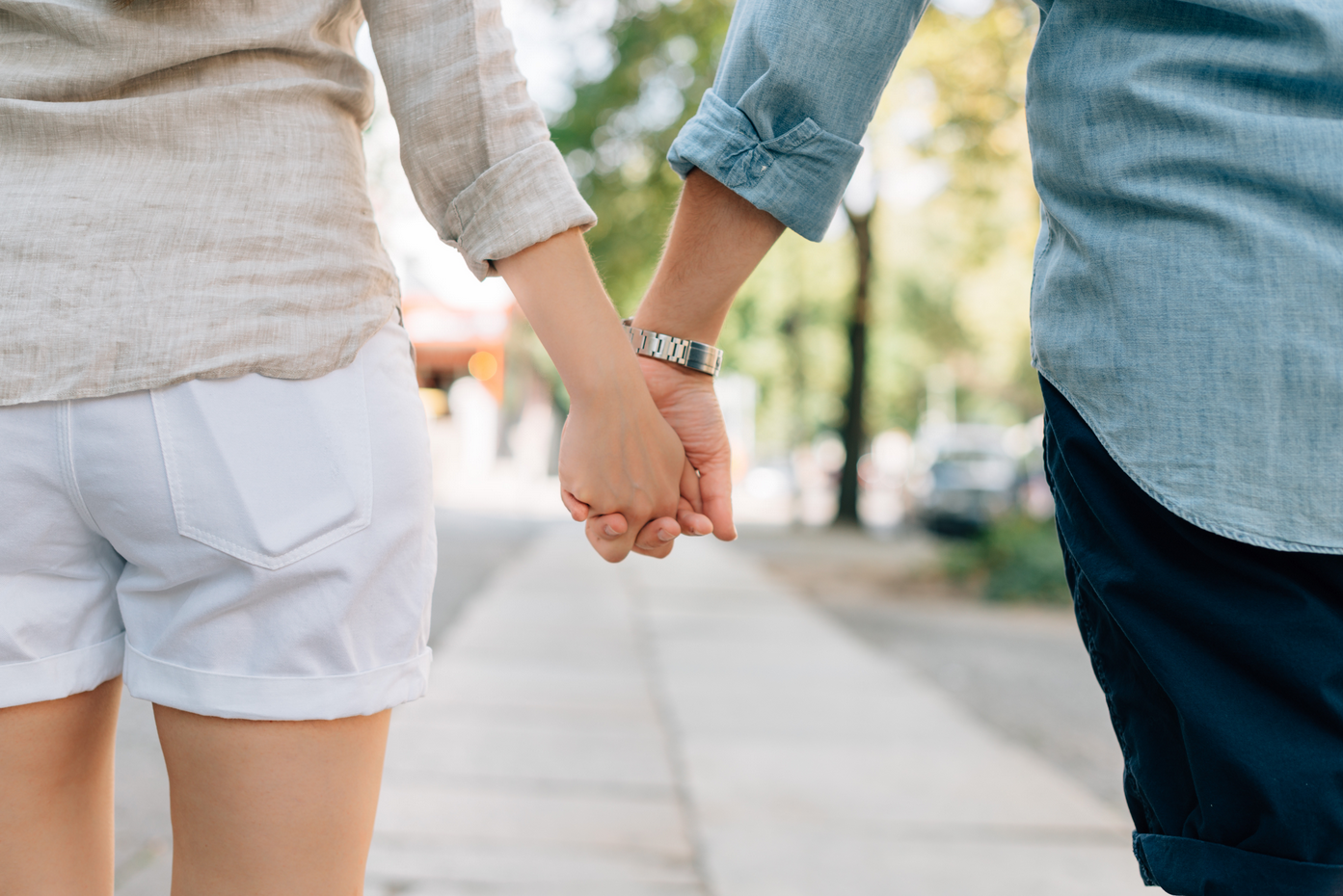 Close-up of two people holding hands.